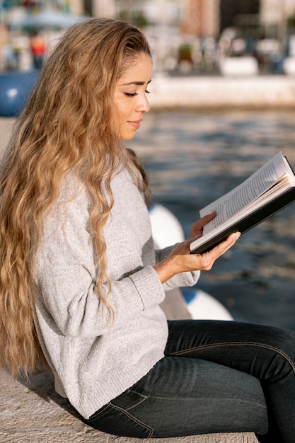 Piękna młoda kobieta czyta książkę