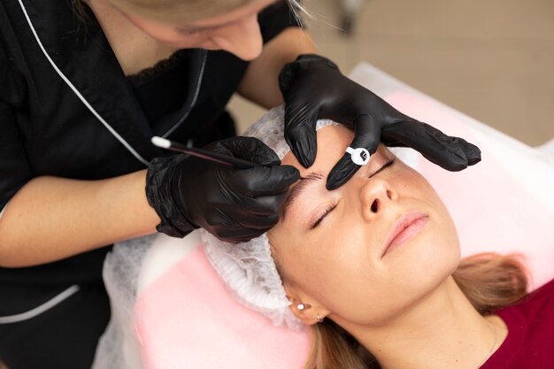 Piękna młoda kobieta przechodzi zabieg microblading