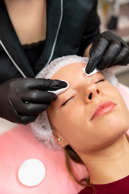 Piękna młoda kobieta przechodzi zabieg microblading