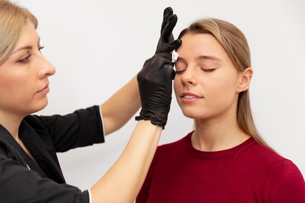 Piękna młoda kobieta przechodzi zabieg microblading