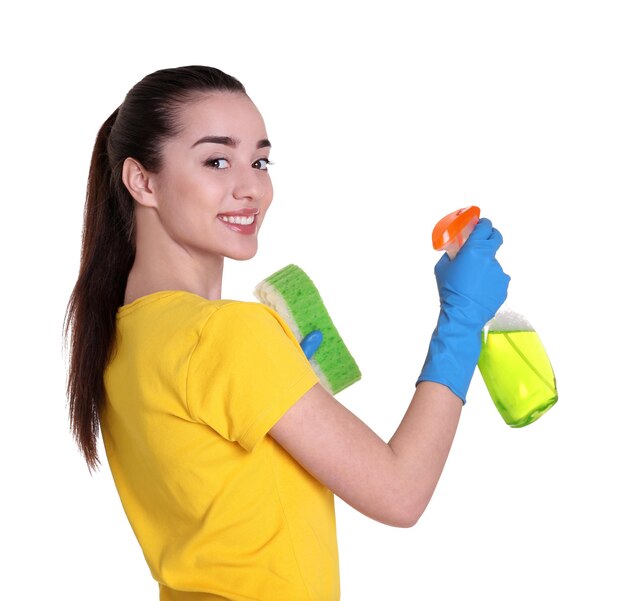Piękna młoda kobieta trzyma gąbkę i spray do mycia na białym tle