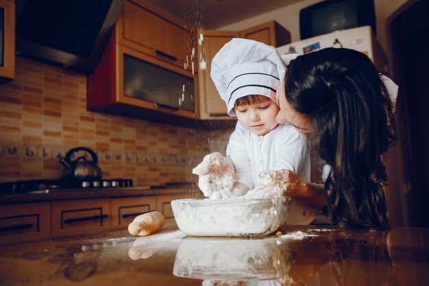 Piękna młoda matka z córeczką gotuje w kuchni w domu