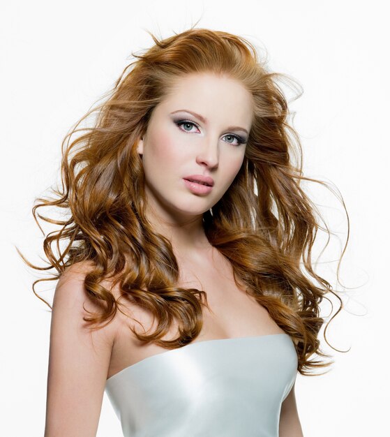 Piękna młoda rudowłosa kobieta z długimi włosami piękna kręcone - na białym tle