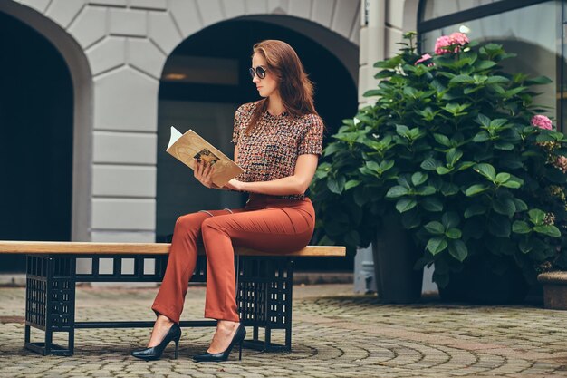 Piękna modna brunetka na sobie modną odzież i okulary przeciwsłoneczne.