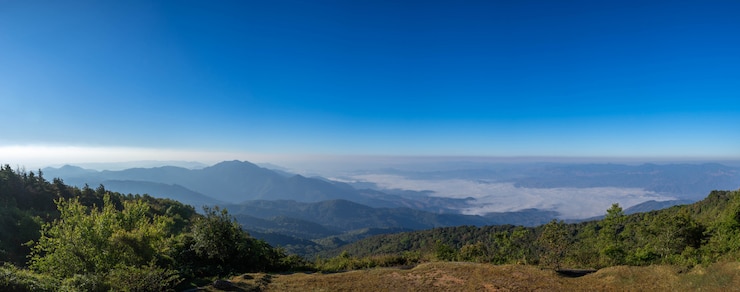 Bezpłatny plik Zdjęcie piękna panoramiczna góra i mgła na niebieskiego nieba tle przy północnym thailand inthanon parkiem narodowym, chiang mai prowincja, panorama krajobrazowy tajlandia