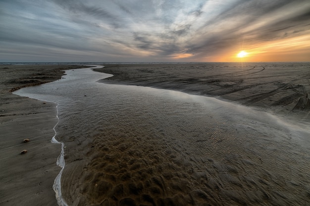 Piękna piaszczysta plaża z morzem w czasie odpływu