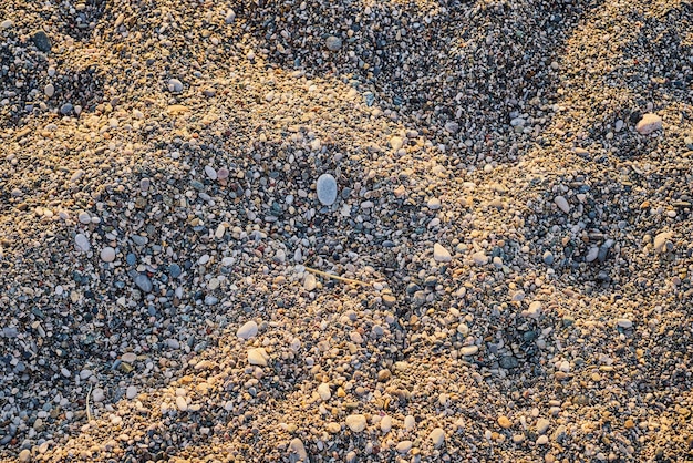 Bezpłatne zdjęcie piękna przyroda kamyk kamień tło kamienna plaża widok z góry abstrakcyjne tło światło słoneczne o zachodzie słońca oświetla plażę
