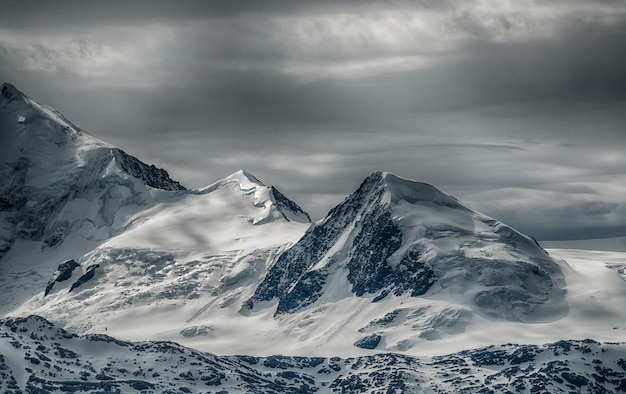 Bezpłatne zdjęcie piękna sceneria pasma górskiego pokrytego śniegiem pod zachmurzonym niebem