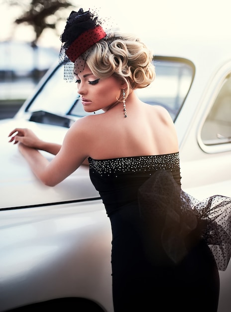 Piękna Seksowna Moda Blond Dziewczyna Model Z Jasnym Makijażem I Kręcone Fryzury W Stylu Retro Siedzi W Starym Samochodzie