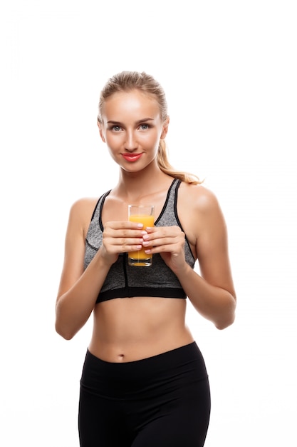 Bezpłatne zdjęcie piękna sportive kobieta trzyma szkło z sokiem