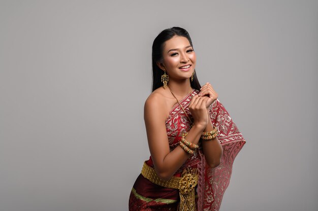 Piękna Tajlandzka kobieta jest ubranym Tajlandzką suknię i szczęśliwego uśmiech.