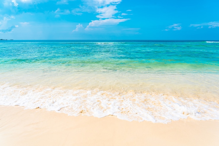 Bezpłatny plik Zdjęcie piękna tropikalna pusta plaża morza oceanu z białym chmurem na niebieskim tle nieba