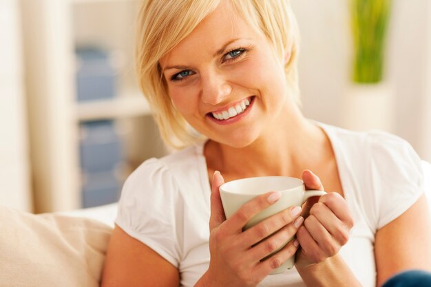 Piękna uśmiechnięta kobieta z filiżanką kawy
