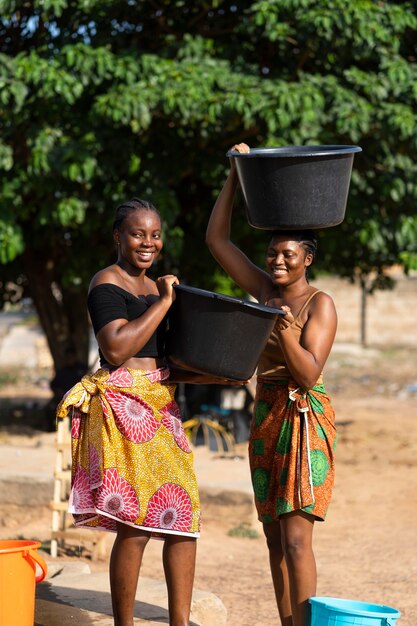Piękne afrykańskie kobiety przynoszące wodę