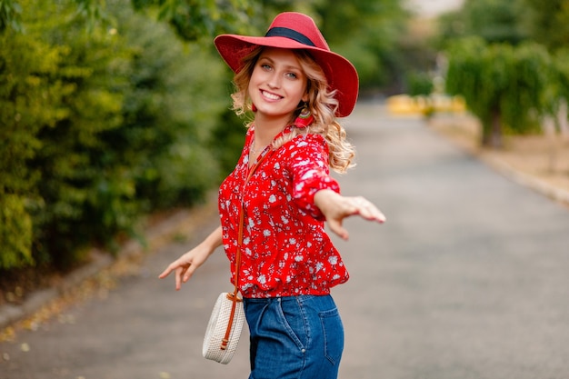 Piękne atrakcyjne stylowe blond uśmiechnięta kobieta w słomkowy czerwony kapelusz i bluzka letni strój