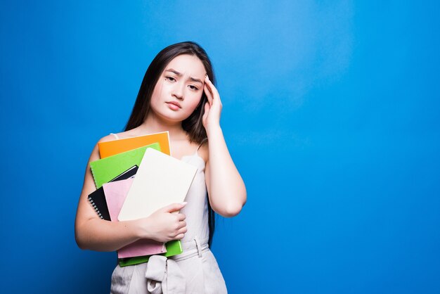 Piękne azjatyckie młoda kobieta czytanie książki na białym tle na niebieskiej ścianie