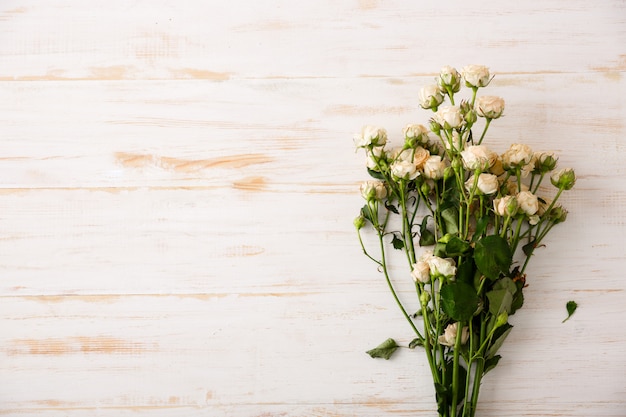 Piękne białe róże na drewnianym stole