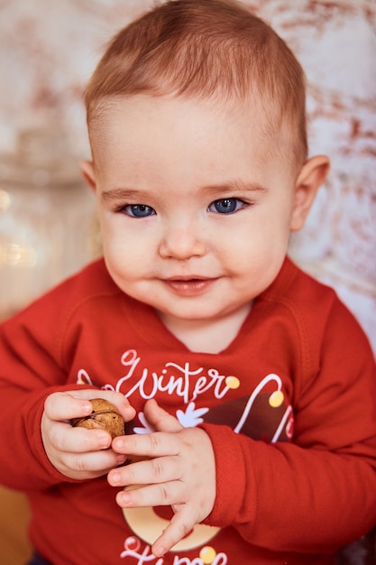 Piękne dziecko o niebieskich oczach trzyma nakrętkę