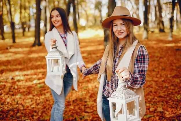 Piękne dziewczyny bawią się w jesiennym parku