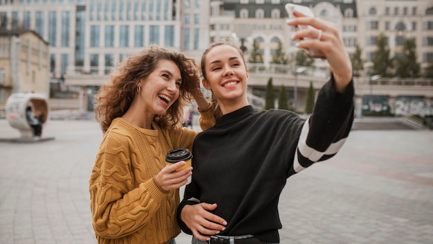 Bezpłatne zdjęcie piękne dziewczyny razem biorąc selfie