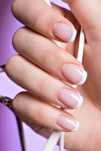Piękne kobiece paznokcie z pięknym francuskim białym manicure