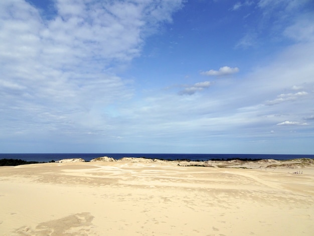 Piękne krajobrazy piaszczystej plaży pod zachmurzonym niebem w Łebie
