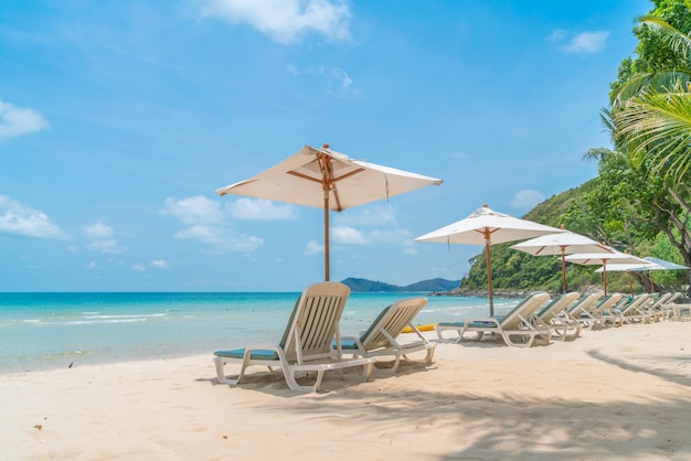 Piękne leżaki z parasolem na tropikalnej, piaszczystej plaży,