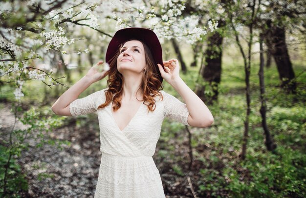 Piękne młoda kobieta stałego w pobliżu kwitnienia drzewa
