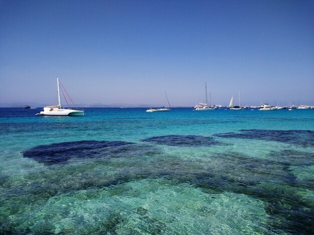 Piękne ujęcie białych łodzi na wybrzeżu w pobliżu Formentery w Hiszpanii