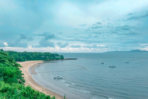 Piękne ujęcie plaży z łodziami na wodzie pod błękitne niebo pochmurne