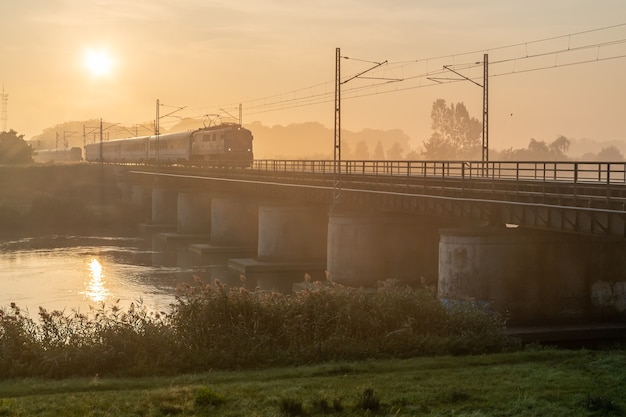Piękne ujęcie pociągu przejeżdżającego przez most w słoneczny dzień