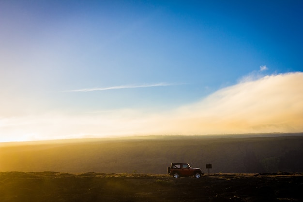 Bezpłatne zdjęcie piękne ujęcie samochodu terenowego na wzgórzu z błękitnym niebem w tle w ciągu dnia
