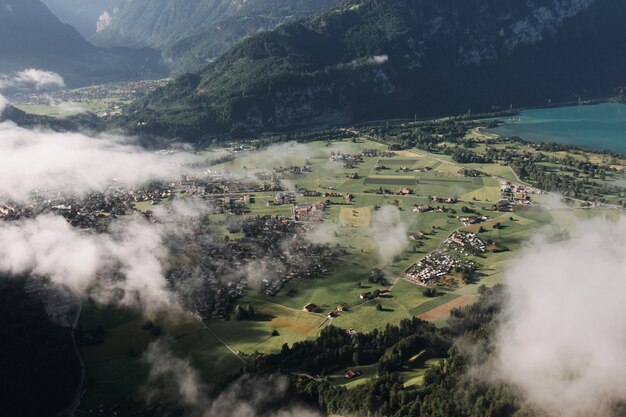 Piękne zdjęcia lotnicze miasta otoczonego górami pokrytymi mgłą