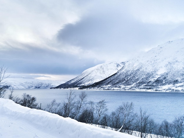 Piękne zdjęcie zamarzniętego jeziora Kattfjordvatnet i ośnieżonych gór w Norwegii