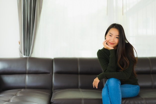 Pięknego Portreta Młoda Azjatykcia Kobieta Siedzi Relaksuje Na Kanapie