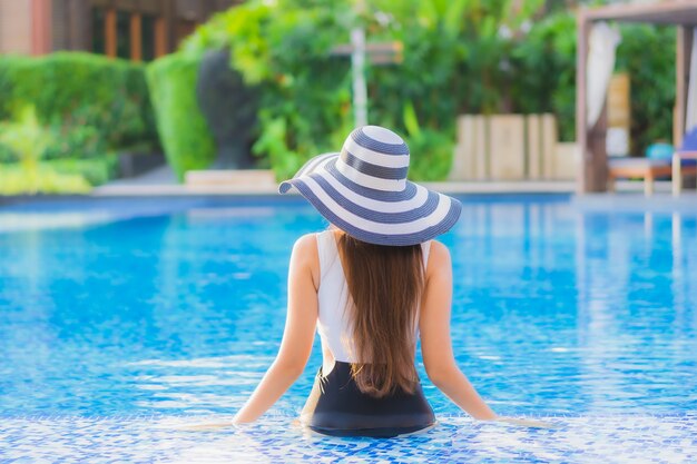Pięknego portreta młodej azjatykciej kobiety szczęśliwy uśmiech relaksuje wokoło pływackiego basenu w hotel w kurorcie