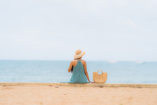 Pięknego portreta młodych azjatykcich kobiet szczęśliwy uśmiech relaksuje wokoło plażowego dennego oceanu