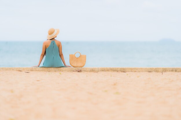 Pięknego portreta młodych azjatykcich kobiet szczęśliwy uśmiech relaksuje wokoło plażowego dennego oceanu