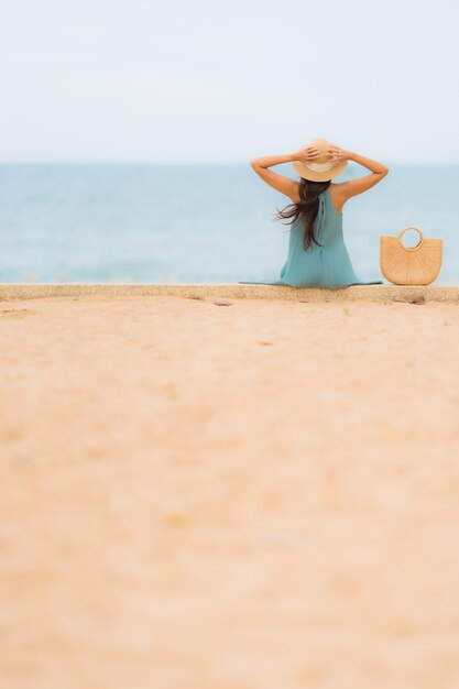 Pięknego portreta młodych azjatykcich kobiet szczęśliwy uśmiech relaksuje wokoło plażowego dennego oceanu