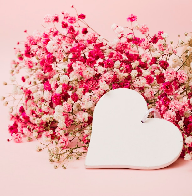 Piękny bukiet kwiatów oddech dziecka z białym kształcie serca na różowym tle