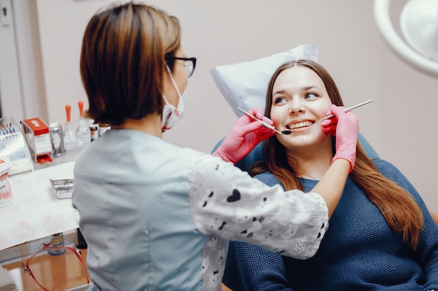 Bezpłatne zdjęcie piękny dziewczyny obsiadanie w dentysty biurze