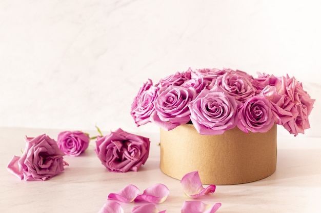 Piękny kwiatowy bukiet z różowymi różami w pudełku na różowym tle