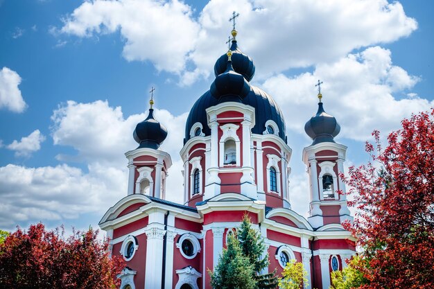 Piękny mołdawski punkt orientacyjny Klasztor Curchi widoczny za czerwonymi drzewami