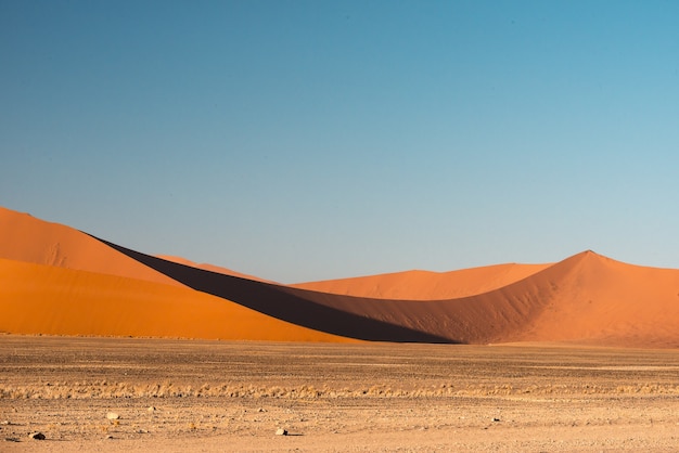 Piękny obraz wydm Parku Narodowego Namib na tle gór z brązowym piaskiem