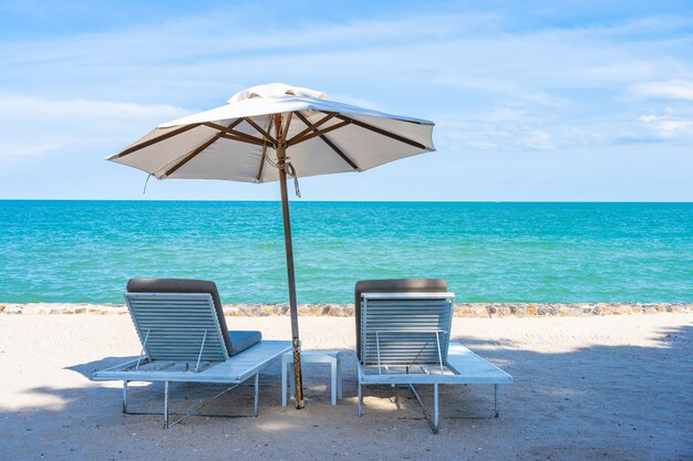 Piękny parasol i krzesło wokół plaży morze ocean z błękitne niebo do podróży