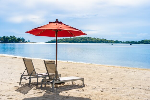 Piękny plenerowy tropikalny plażowy denny ocean z parasolowym krzesłem i holu pokładem wokoło tam na biel chmury niebieskim niebie