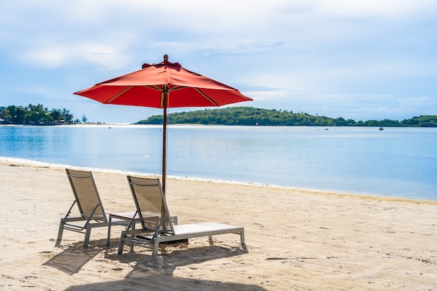 Piękny plenerowy tropikalny plażowy denny ocean z parasolowym krzesłem i holu pokładem wokoło tam na biel chmury niebieskim niebie