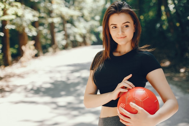 Piękny sportsgirl w lato pogodnym parku