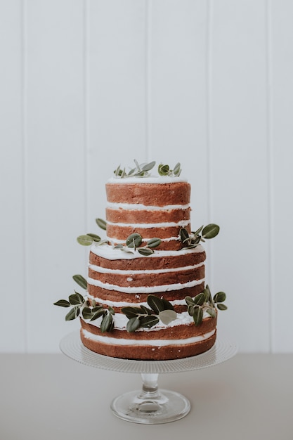 Bezpłatne zdjęcie piękny tort weselny urządzone z eukaliptusa na białym tle drewnianych