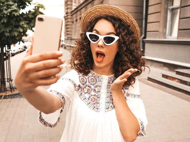 Piękny uśmiechnięty model z fryzurą afro loki ubrany w letnią sukienkę hipster.